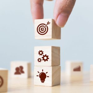 Concept of business strategy and action plan. Businessman hand putting wood cube block on top with icon